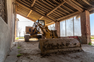 Fototapeta na wymiar photograph of a scraper parked in the farmhouse.farmhouse