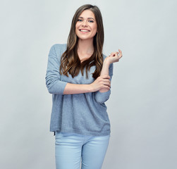 Casual woman with long hair standing in front of gray studio iso