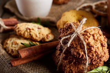 Traditional Christmas tea concept with a cup of hot tea, cookies and decorations on a wooden background, selective focus