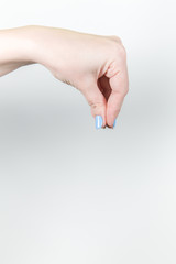 Vertical color photography of young female hand holding something virtual and invisible with all fingers isolated on white background. With copy space.