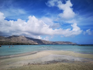 Beautiful beach near mountains covered with clouds