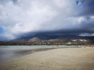 Beautiful beach near mountains covered with clouds