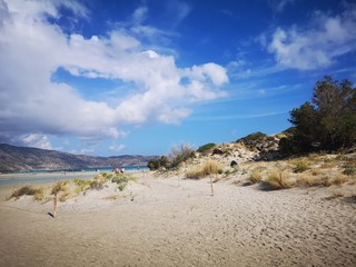 Sand dunes with lagoon and mountains in background