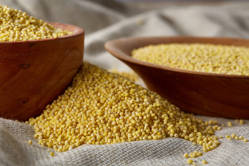 Two bowls of millet on a wooden background, top view, close-up, selective focus.