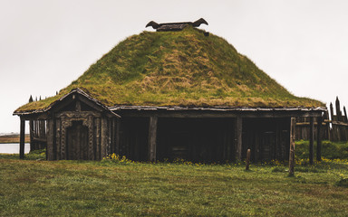 old viking village in iceland with foggy hill. old wooden buildings covered in grass