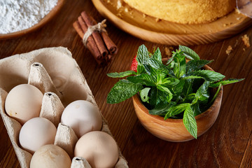 Fresh mint leaves in a bowl on wooden table, close-up, selective focus, shallow depth of field.