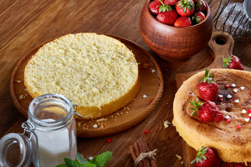 Delicious cake with fresh organic strawberries on cutting board over wooden background, close-up, selctive focus.