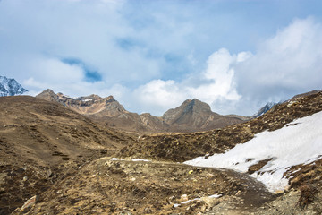 Mountain landscape with snow on the trail and white clouds, Nepal.