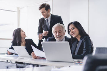 Marketing team consulting sales plan with supervisor senior manager in conference room before presenting to client.
