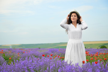 Fototapeta na wymiar young girl is in the lavender field, beautiful summer landscape with flowers