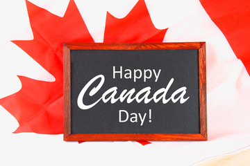 Fototapeta na wymiar Chalkboard with the word Happy Canada Day on the national flag. Feast of 1 July.