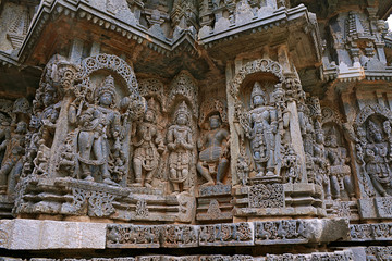 Fototapeta na wymiar Ornate wall panel reliefs depicting from left Bhairava, Other deities, a drumer and Lord Vishnu, Kedareshwara temple, Halebidu, Karnataka