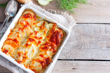 Graten from courgettes and young potatoes with a rosy crust of mozzarella, top view, copy space