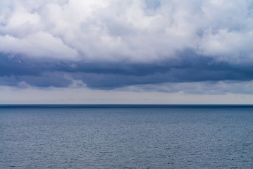 Naklejka na ściany i meble dense rain clouds over the sea