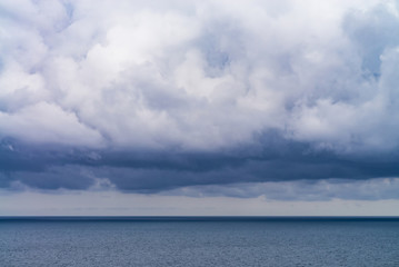 Naklejka na ściany i meble dense rain clouds over the sea
