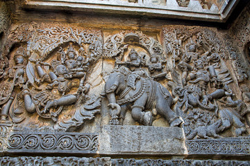 Ornate wall panel reliefs depicting from left Garuda carrying Vishnu, Lord Indra and Indrani on elephant Eirawat and Vishnu rescuing Gajendra from crocodile, Hoysaleshwara temple, Halebidu, Karnataka