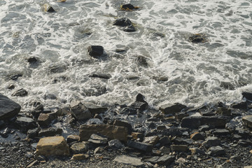 Sea waves, sea foam, break up on the coastal stones
