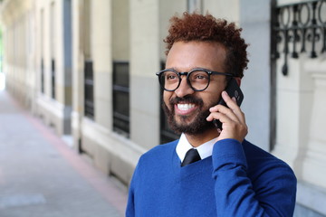 Ethnic elegant male calling by phone outdoors 