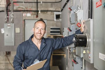 Man Technician servicing at work on electric room