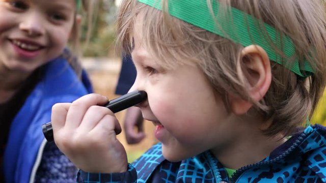 Body art painting animator paints face of little boy entertaining children on birthday theme party
