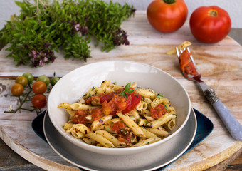 eine Schüssel Pasta mit Tomatensoße und viel Basilikum