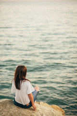 Fototapeta na wymiar Beautiful woman sitting on a rock looking to the horizon