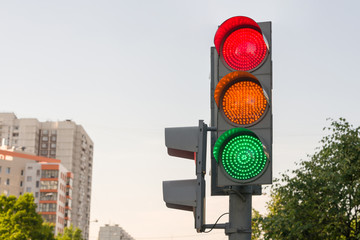 Street car traffic light with burning green, orange and red lights at the same time