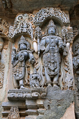 Ornate wall panel reliefs depicting from left Goddess Lakshmi the wife of Vishnu, and Vishnu, Kedareshwara temple, Halebidu, Karnataka