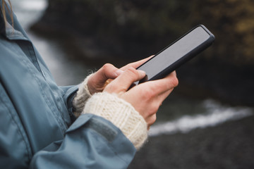 Iceland, hands of woman holding smartphone
