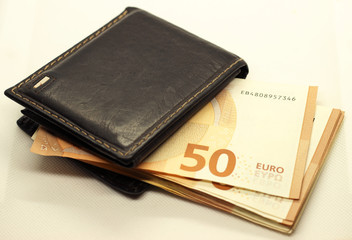 Money in your wallet. Denominations look out of the purse. Paper euros.