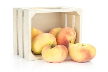 Fresh ripe Saturn peaches out a wooden box isolated on white background.