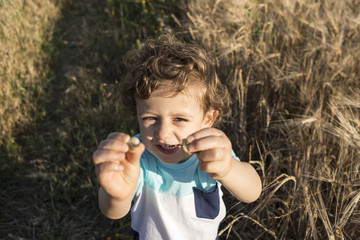Child playing with some snails.