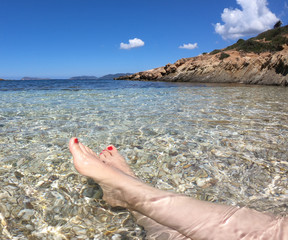Vacanze nel mare di sardegna, prospettiva in prima persona sulle gambe