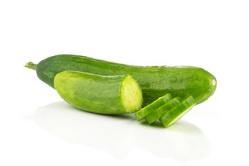One fresh green mini cucumber with a half and three slices isolated on white background.