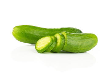 One fresh green mini cucumber with a sliced half and three slices isolated on white background.
