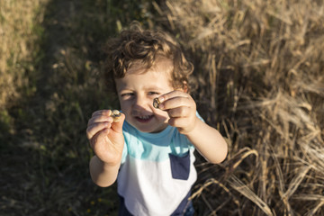 Child playing with some snails.