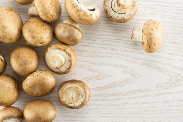 Fresh raw brown champignons table top on grey wood background.