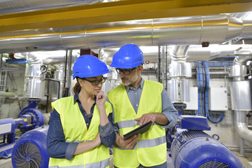 Industrial engineers working in recycling plant with tablet