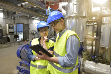 Industrial engineers working in recycling plant with tablet