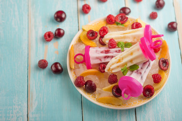 Homemade Eskimony from yogurt, in a plate ice cream on sticks, top view, flat lay with empty space for an inscription. Right color, summer mood.