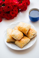 puff patty  with cheese on plate, red roses, coffee