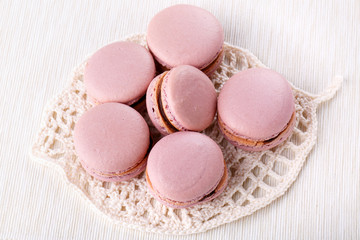 Heap of pink macaroons - French cookies on white table.