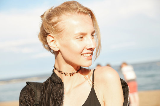 Portrait of a blonde model girl on the beach with wind in her hair