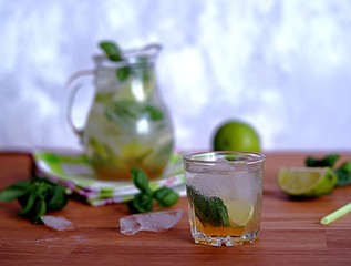 Cold summer drink, lemonade with lime and basil on the basis of sparkling water and sugar syrup. Served with ice. Summer concept.