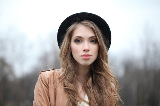 Attractive young woman in hipster hat outdoors, portrait