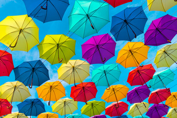Fototapeta na wymiar Colorful umbrellas background. Multi-colored umbrellas in the sky. Street decoration.