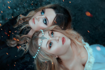 Two girls of the elements, opposites, love each other with affection. Around them, sparks, flashes...
