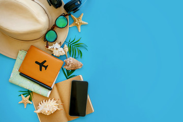 summer vacation concept flat lay. hipster hat, passport, map, phone, sunglasses, headphones on blue trendy paper with shells. space for text. stylish creative image. travel and wanderlust