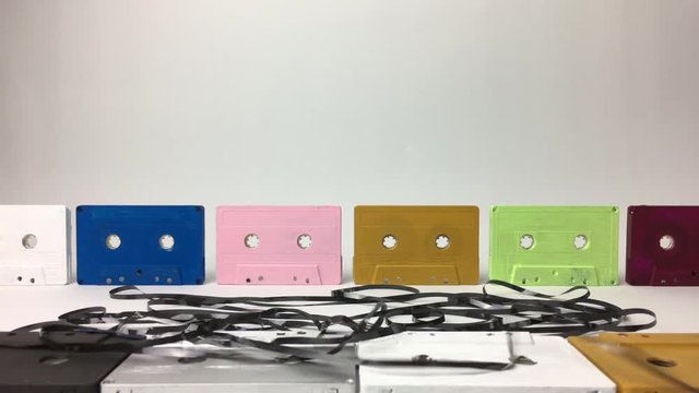 Cinta de casete recogiendose, con casetes al fondo y delante.