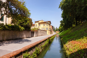 Fototapeta na wymiar Lucca old town cityscape with canal along fortified city wall Tuscany Italy